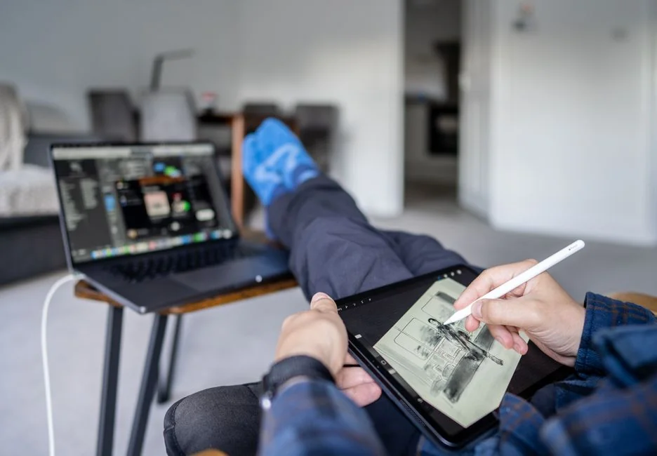 Build your dream website for your future. A laptop, MacBook, on top of a portable table with coffee tea mug on the side.